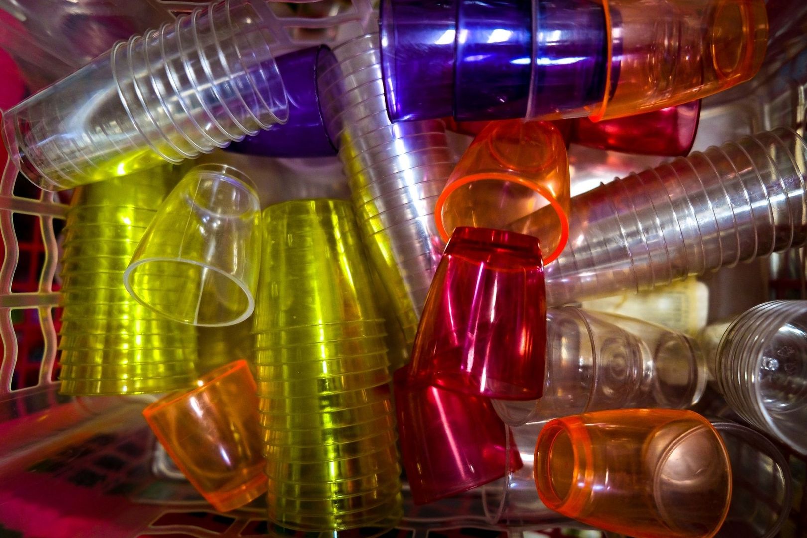 Farverige genbrugskrus og plastdele stablet tæt sammen